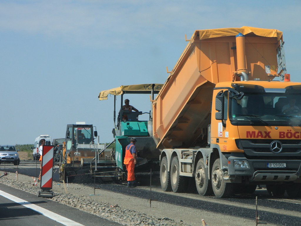 Asphalt paver and tipper laying a new road surface